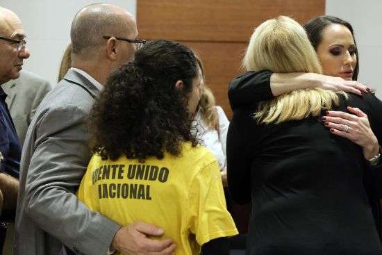 Florida Circuit Judge Elizabeth Scherer, right, hugs Jennifer Guttenberg following the sentencing hearing for Parkland school shooter Nikolas Cruz at the Broward County Courthouse in Fort Lauderdale, Fla., Nov. 2, 2022. Guttenberg's daughter, Jaime, was killed in the 2018 shootings. A state commission concluded Monday that Scherer should be publicly reprimanded for showing bias toward the prosecution.