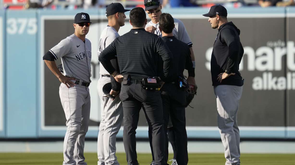 New York Yankees right fielder Aaron Judge, center right, is checked out after catching a fly ball hit by Los Angeles Dodgers' J.D. Martinez during the eighth inning of a baseball game in Los Angeles, Saturday, June 3, 2023.
