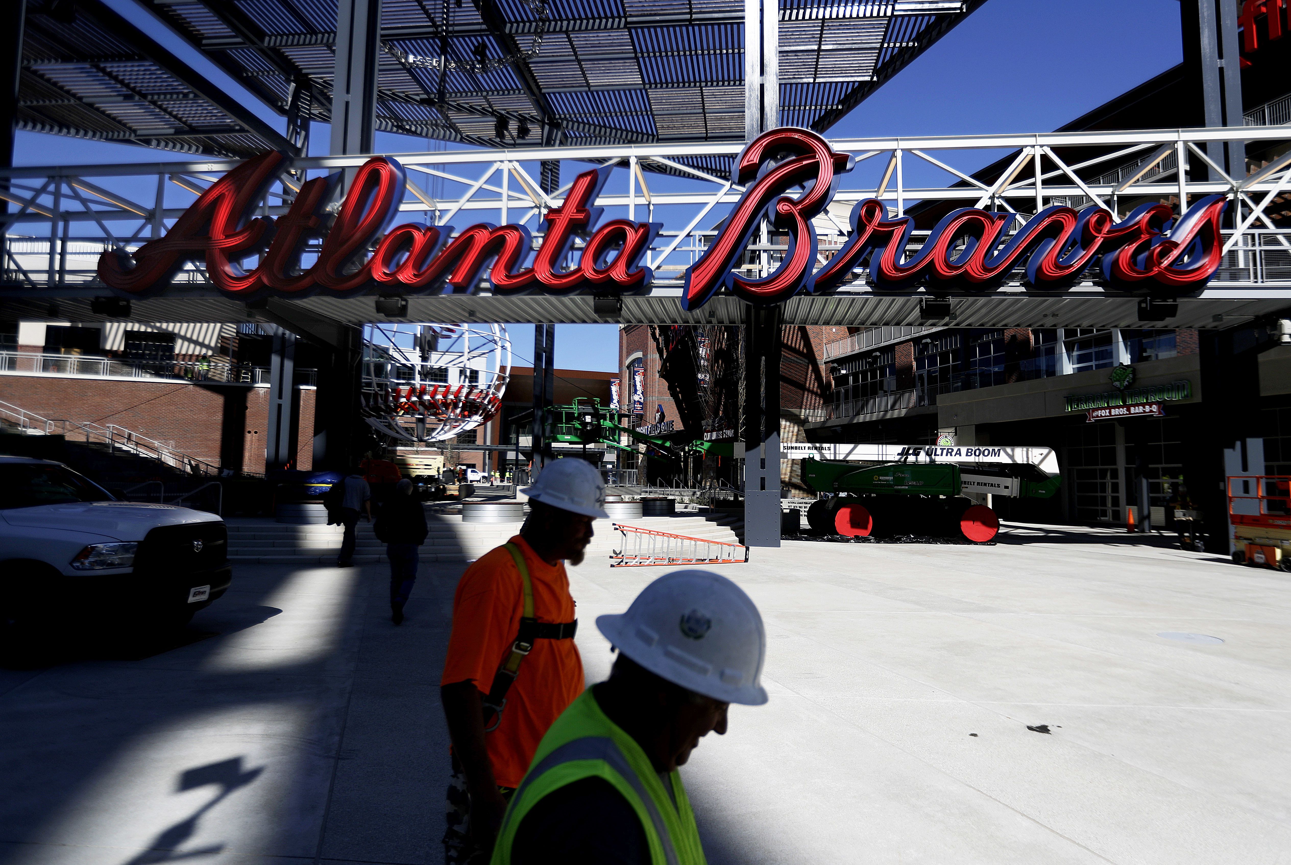 Construction workers walk past a mixed-use area to feature restaurants and retail stores at SunTrust Park, the Atlanta Braves’ new baseball stadium in Atlanta, March 9, 2017.