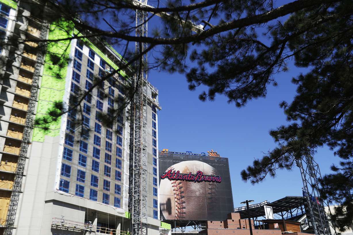 A billboard of a baseball stands next to a hotel under construction with a view into SunTrust Park, the Atlanta Braves’ new baseball stadium in Atlanta on March 9, 2017.