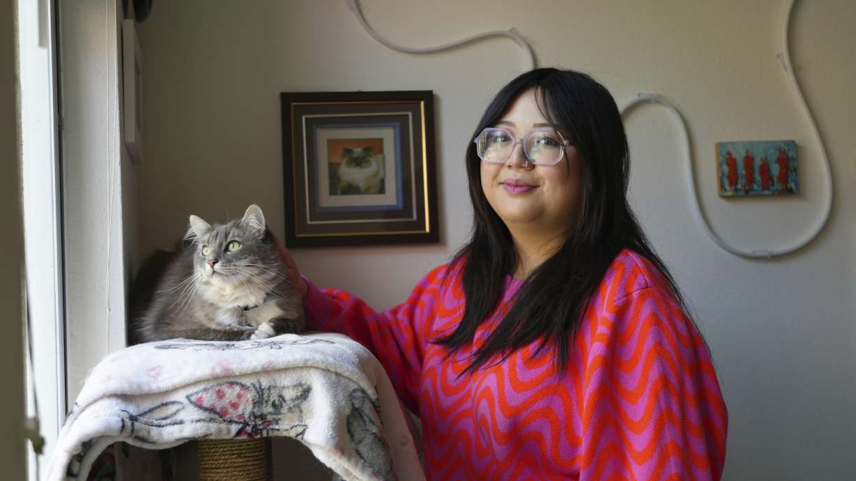 Celina Chanthanouvong stands with her cat in her apartment in Emeryville, Calif., on June 2. More than 40 million student loan borrowers will be on the hook for payments starting in late August.