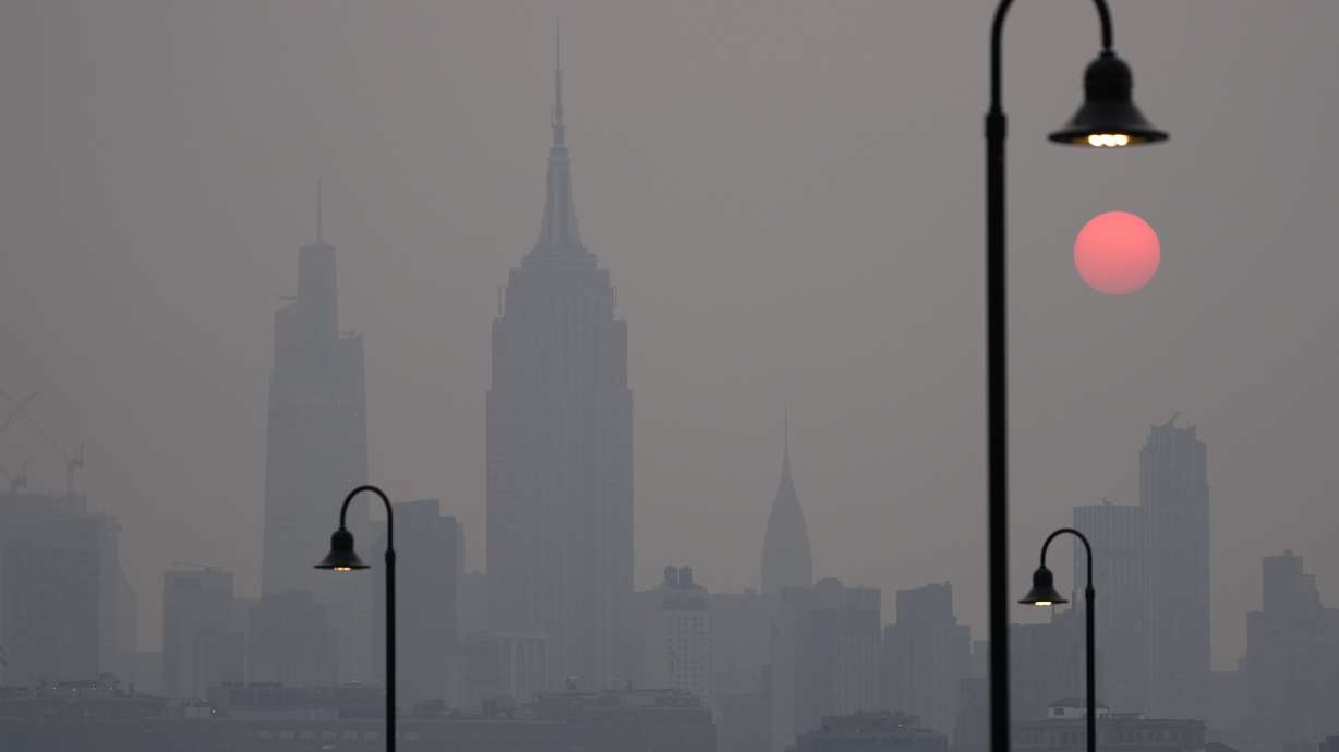 The sun rises over a hazy New York City skyline as seen from Jersey City, N.J., Wednesday. Intense Canadian wildfires are blanketing the northeastern U.S. in a dystopian haze, and prompting warnings for vulnerable populations to stay inside.
