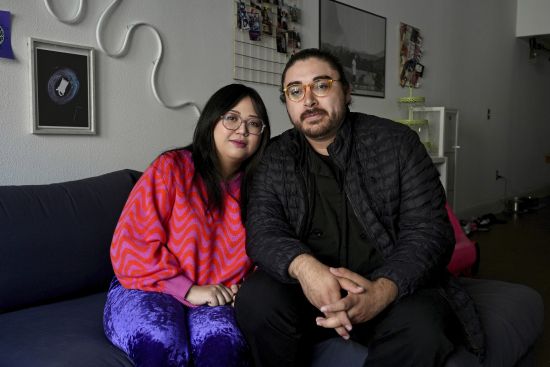 Celina Chanthanouvong and her partner Richard Flores pose in their apartment in Emeryville, Calif., on June 2. After a payment pause that has lasted more than three years, more than 40 million student loan borrowers will be on the hook for payments starting in late August. The pause in repayment has been a lifeline keeping 25-year-old Chanthanouvong afloat.