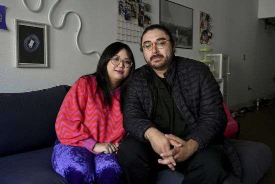 Celina Chanthanouvong and her partner Richard Flores pose in their apartment in Emeryville, Calif., on June 2. After a payment pause that has lasted more than three years, more than 40 million student loan borrowers will be on the hook for payments starting in late August. The pause in repayment has been a lifeline keeping 25-year-old Chanthanouvong afloat.