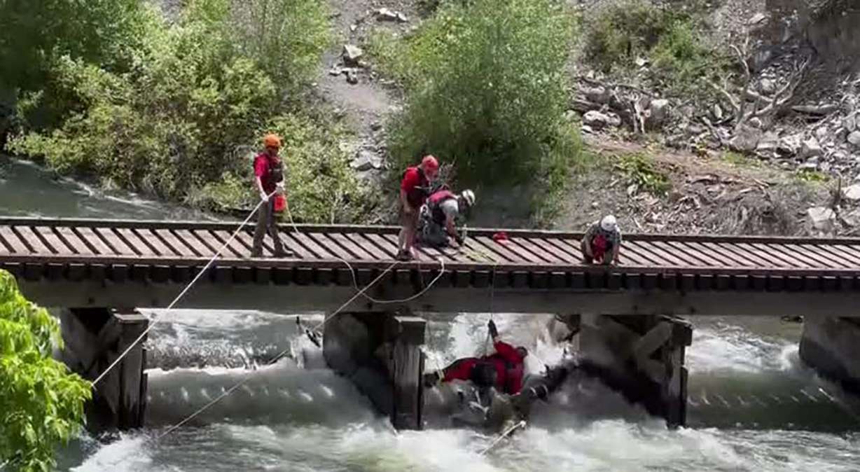 Crews work to clear debris, including a large log, from the Provo River Tuesday. Some people are ignoring warning signs and recreating in dangerous, closed areas of Provo Canyon, officials say.