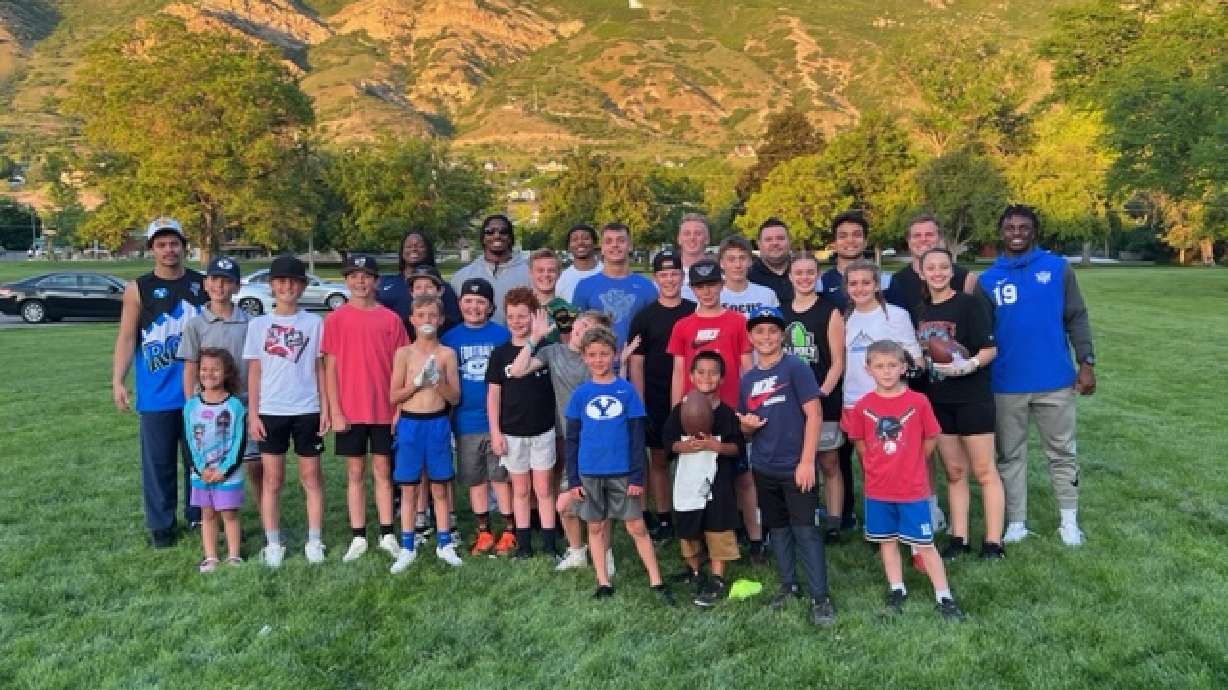 Jake Brandon, fourth from right on back row, co-founder of CougConnect, poses with young fans at a CougConnect event at a local park in Utah County.