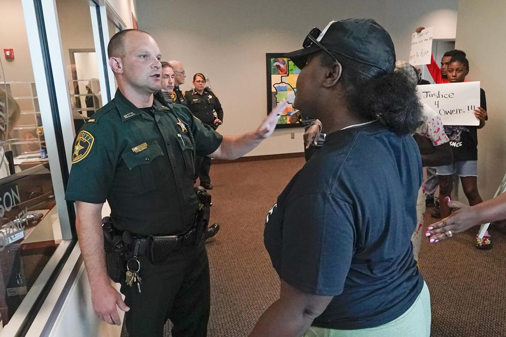 A protester, right, confronts a Marion County sheriff deputy at the Marion County Courthouse, Tuesday in Ocala, demanding the arrest of a woman who shot and killed Ajike Owens, a 35-year-old mother of four, last Friday night, June 2.