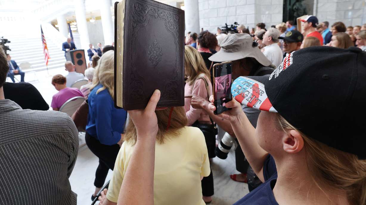 A Bible is held at a rally at the Capitol in Salt Lake City on June 7 to voice concern regarding the decision of the Davis School District to remove the Bible from some schools. The board voted unanimously Tuesday to reverse the decision.