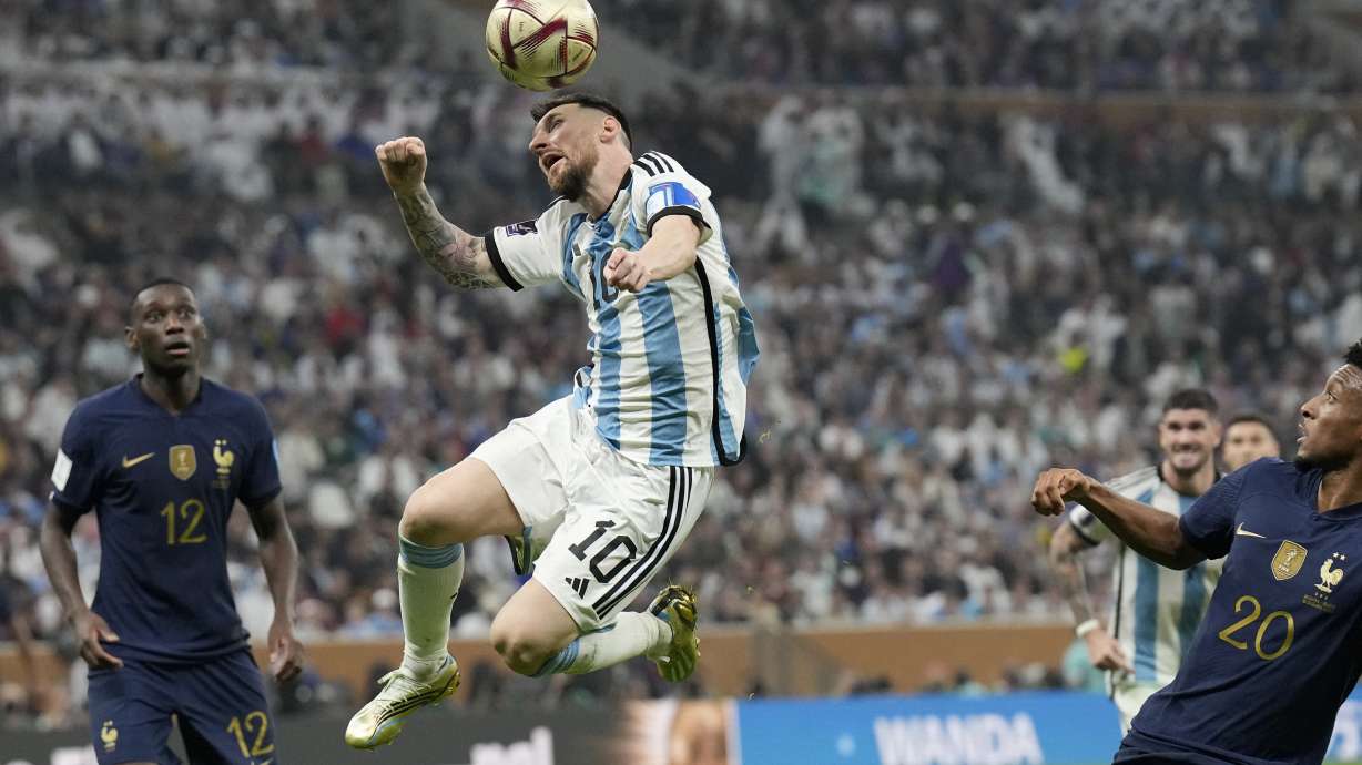 FILE - Argentina's Lionel Messi heads the ball next to France's Kingsley Coman, right, during the World Cup final soccer match between Argentina and France at the Lusail Stadium in Lusail, Qatar, Sunday, Dec. 18, 2022. Lionel Messi says he is coming to Inter Miami and joining Major League Soccer. After months of speculation, Messi announced his decision Wednesday, June 7, 2023,to join a Miami franchise that has been led by another global soccer icon in David Beckham since its inception but has yet to make any real splashes on the field.