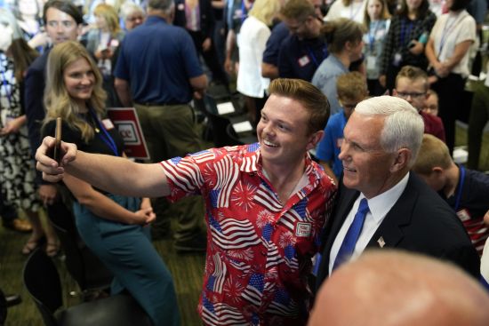 Republican presidential candidate former Vice President Mike Pence poses for a photo with an audience member at a campaign event, Wednesday in Ankeny, Iowa.