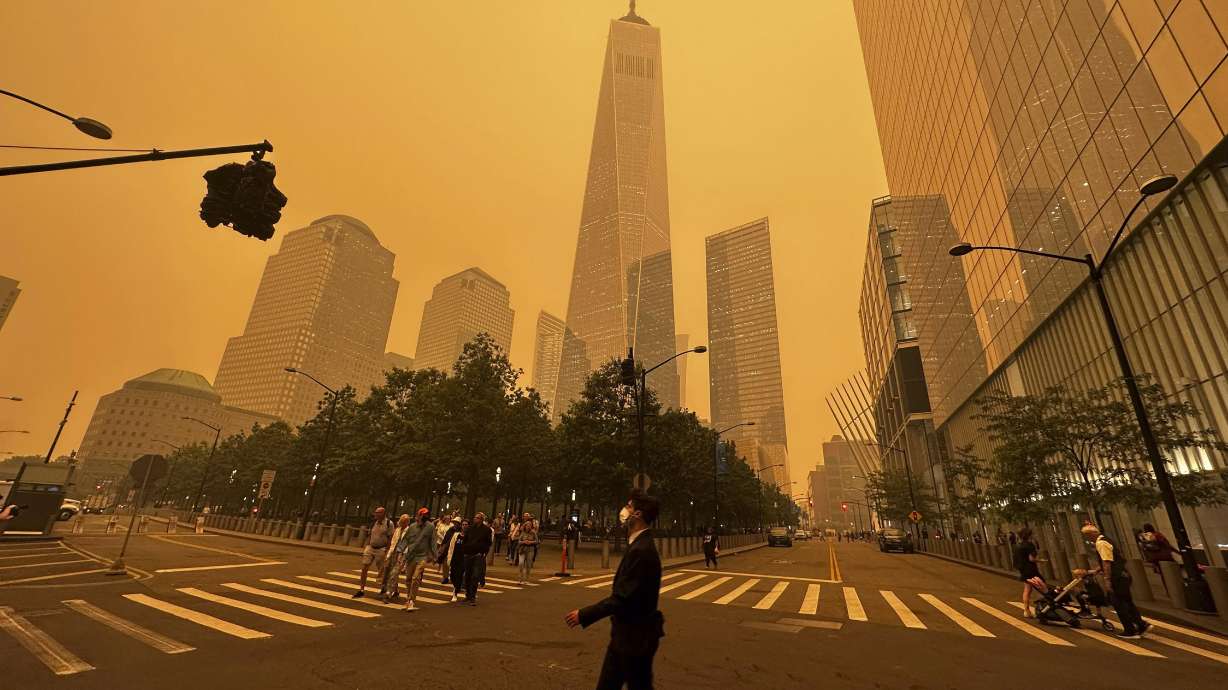 Pedestrians pass the One World Trade Center, center, amidst a smokey haze from wildfires in Canada, Wednesday, in New York. Smoke from Canadian wildfires poured into the U.S. East Coast and Midwest on Wednesday.