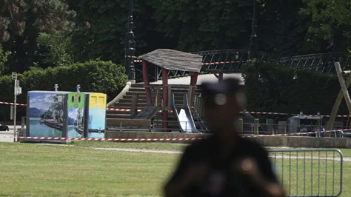 A police officer stands by the scene after a knife attack Thursday in Annecy, French Alps. A man with a knife stabbed several very young children.