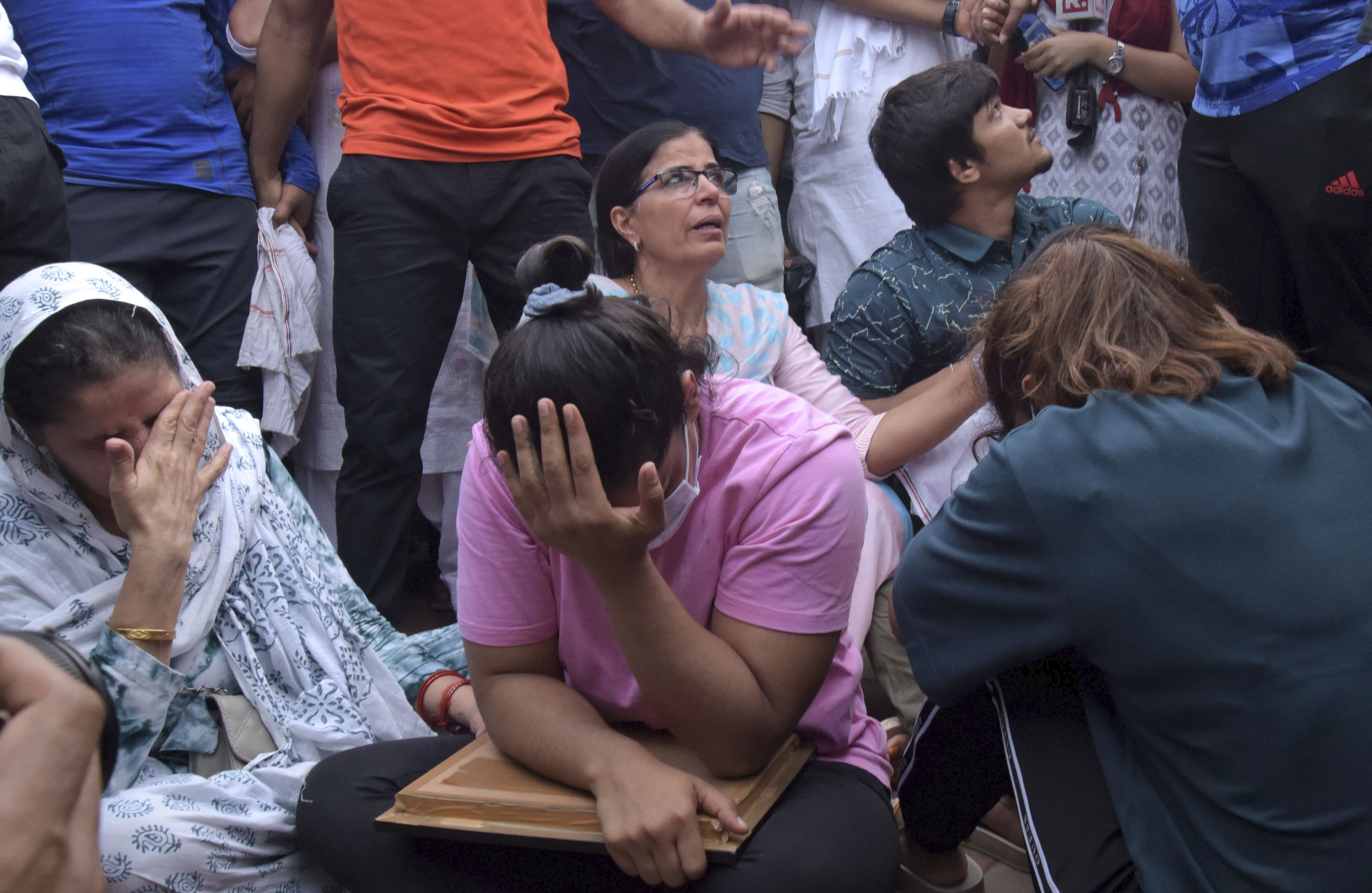 Sakshi Malik, an Indian wrestler who won a bronze medal at the 2016 Summer Olympics, sits with fellow wrestlers by the banks of the river Ganges in Haridwar, India, Tuesday, May 30, 2023. India's top wrestlers held off from throwing their medals into the country's sacred Ganges River on Tuesday as part of an ongoing protest against sexual harassment after community leaders intervened and persuaded them against doing so. They accuse Brij Bhushan Sharan Singh, the president of the Wrestling Federation of India, of sexually harassing seven young female wrestlers, including a minor. 