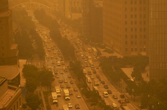 Traffic moves along Wednesday in New York, amidst smokey haze from wildfires in Canada. Smoke from Canadian wildfires poured into the U.S. East Coast and Midwest on Wednesday, covering the capitals of both nations in an unhealthy haze, holding up flights at major airports and prompting people to fish out pandemic-era face masks.