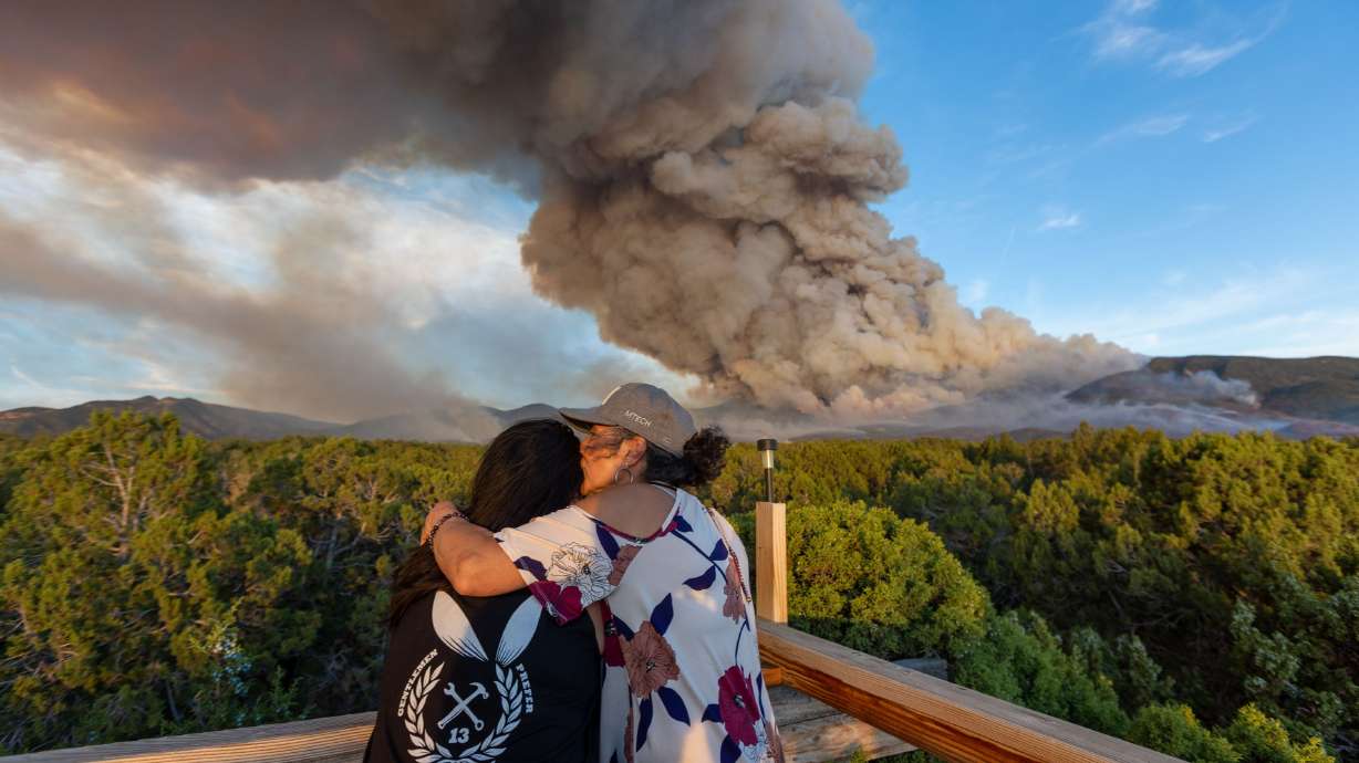 Vivian Rogers is held by Bernadette Parra as the two watch a fire burn from their property in Fillmore in central Utah on July 8, 2022. As smoke from wildfires burning in Canada blanket the Northeast, Utah Sen. Mike Lee pointed out that wildfires in the West are an "ongoing" and "severe" problem.
