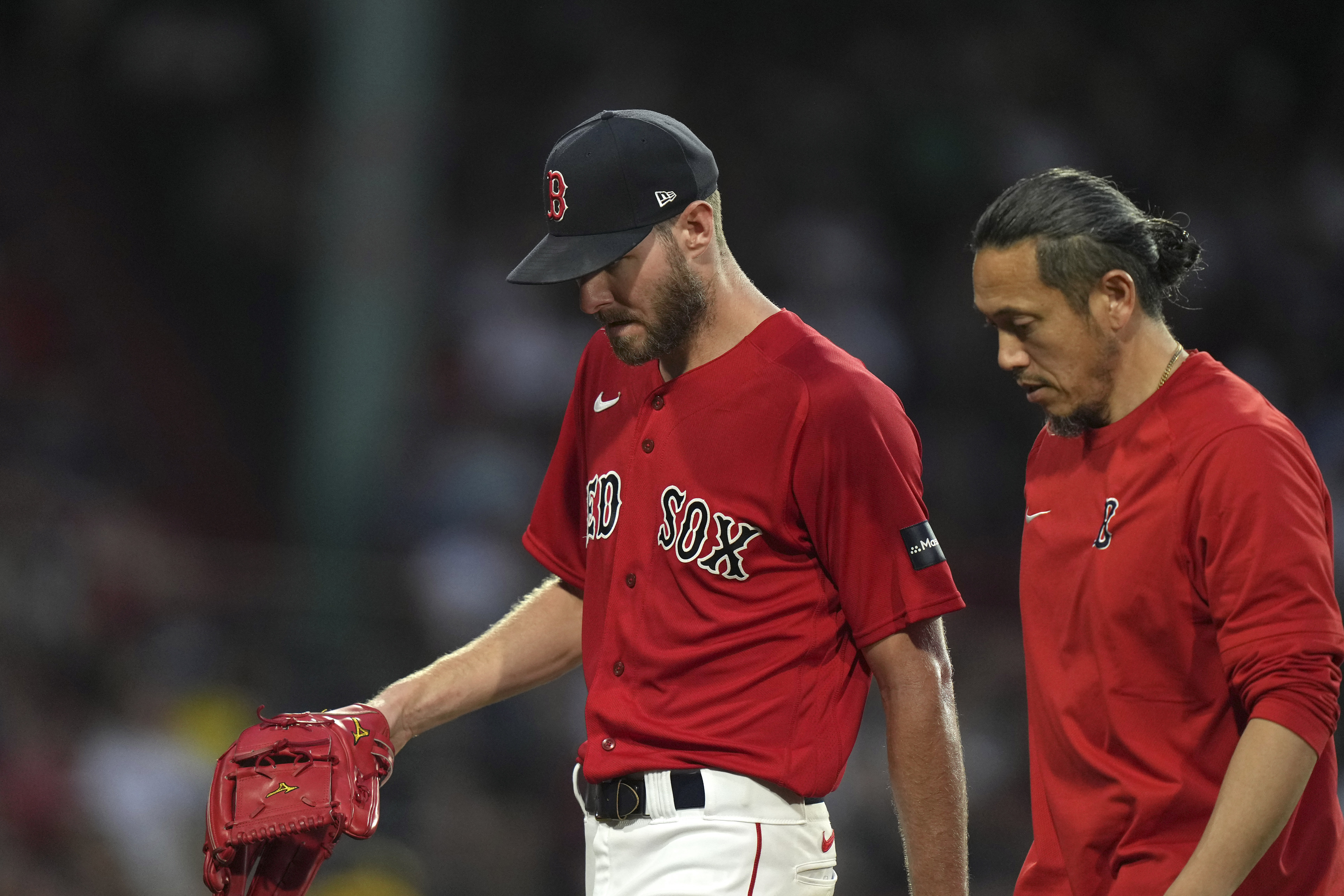 Boston Red Sox's Chris Sale, left, walks to the dugout after being removed during the fourth inning of the team's baseball game against the Cincinnati Reds, Thursday, June 1, 2023, in Boston.