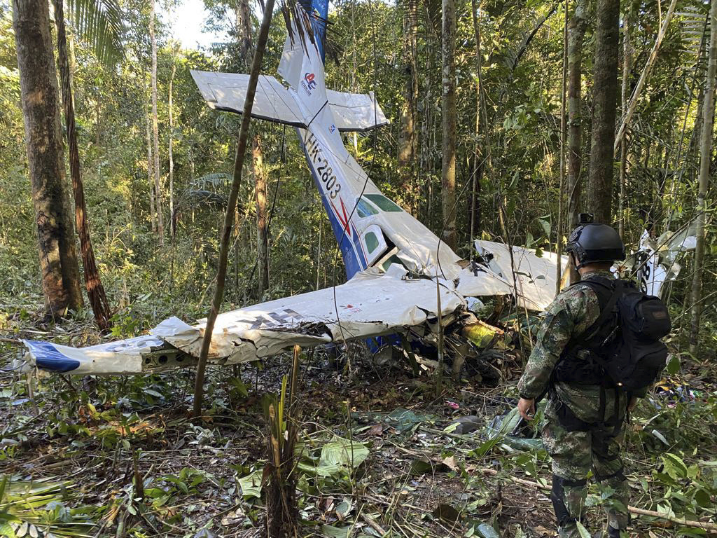 In this photo released by Colombia's Armed Forces Press Office, a soldier stands in front of the wreckage of a Cessna C206, May 18, that crashed in the jungle of Solano in the Caqueta state of Colombia.