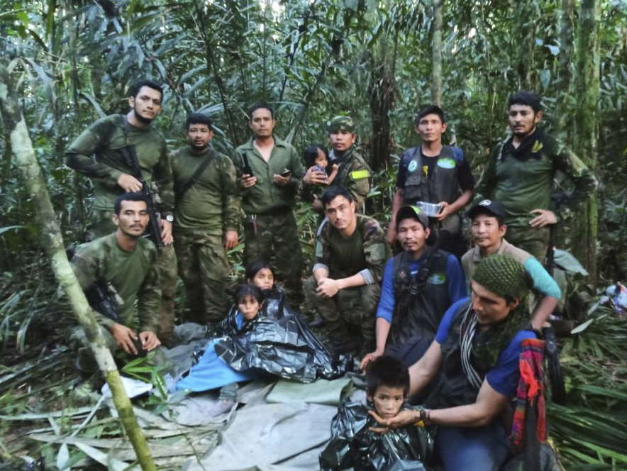 Soldiers and Indigenous men pose for a photo with the four Indigenous brothers who were missing after a deadly plane crash, in the Solano jungle, Caqueta state, Colombia, Friday. 