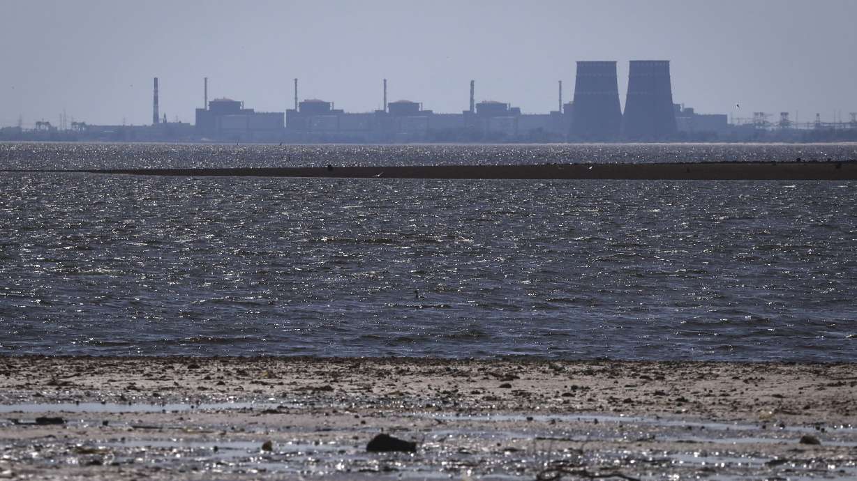 The Zaporizhzhia nuclear power plant, Europe's largest, is seen in the background of the shallow Kakhovka Reservoir after the dam collapse, in Energodar, Russian-occupied Ukraine, Friday. The plant has been under Russian occupation since 2022.