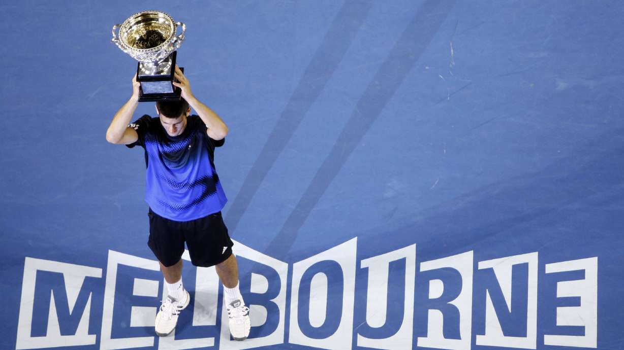 FILE - Serbia's Novak Djokovic holds a trophy after beating Jo-Wilfried Tsonga, of France, in the final of the Men's singles at the Australian Open tennis tournament in Melbourne, Australia, Sunday, Jan. 27, 2008. Djokovic will be trying to set the record for the most Grand Slam singles trophies won by a man when he goes for what would be No. 23 against Casper Ruud in the French Open final on Sunday, June 11, 2023. Djokovic enters that match with 22, tied with his rival Rafael Nadal. Roger Federer, who announced his retirement last year, is next with 20.