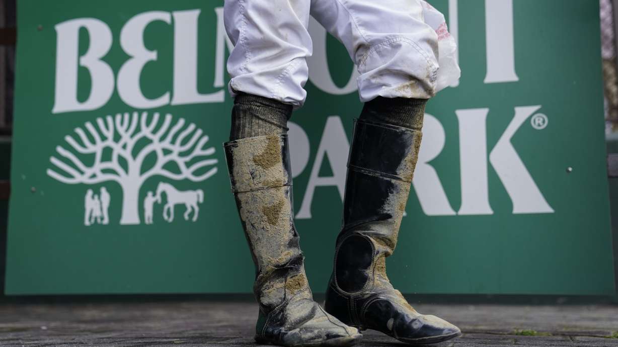 A jockey's boots are caked in mud after an early race ahead of the Belmont Stakes horse race, Saturday, June 10, 2023, at Belmont Park in Elmont, N.Y.