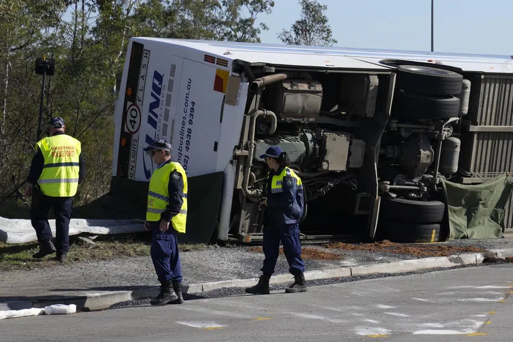 Police inspect a bus on its side near the town of Greta following a crash in the Hunter Valley, north of Sydney, Australia, Monday. The bus carrying wedding guests rolled over on a foggy night, killing and injuring multiple people, police said. 
