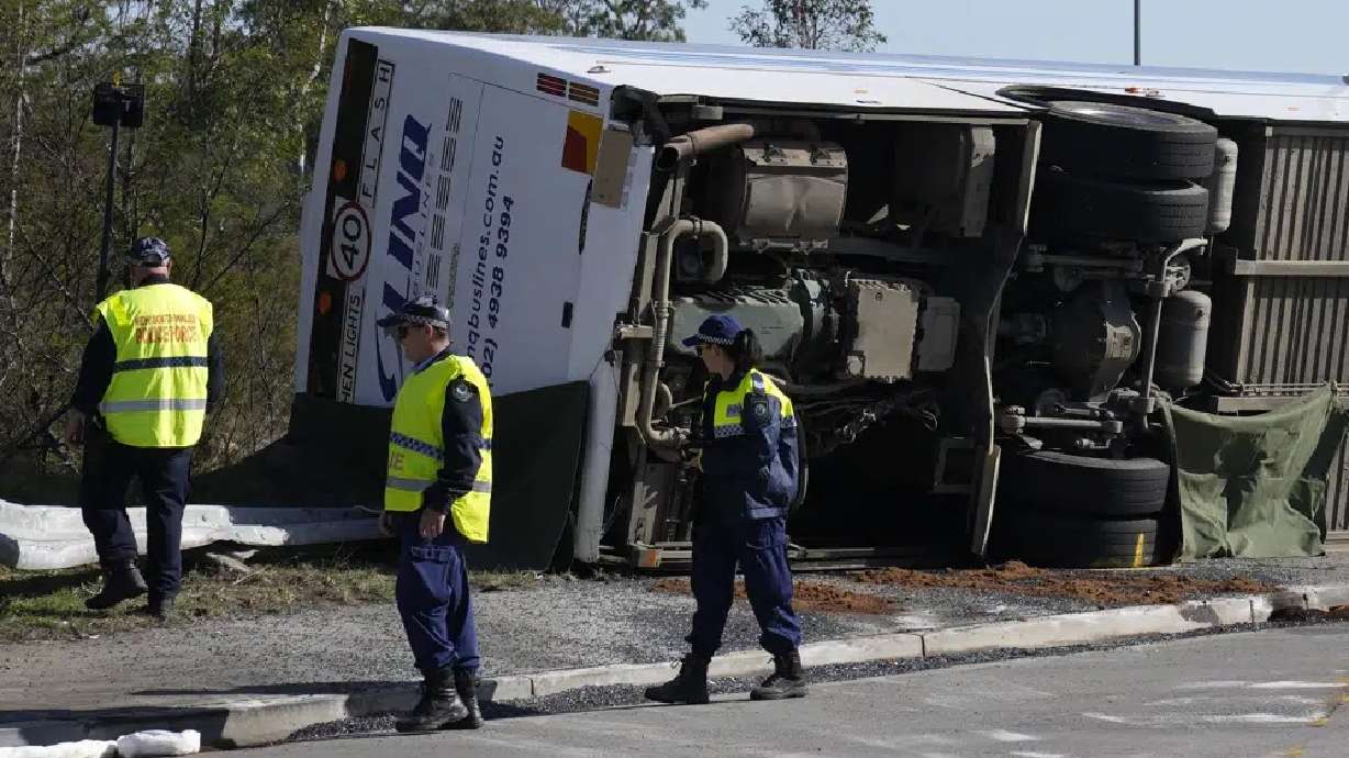 Police inspect a bus on its side near the town of Greta following a crash in the Hunter Valley, north of Sydney, Australia, Monday. The bus carrying wedding guests rolled over on a foggy night, killing and injuring multiple people, police said.