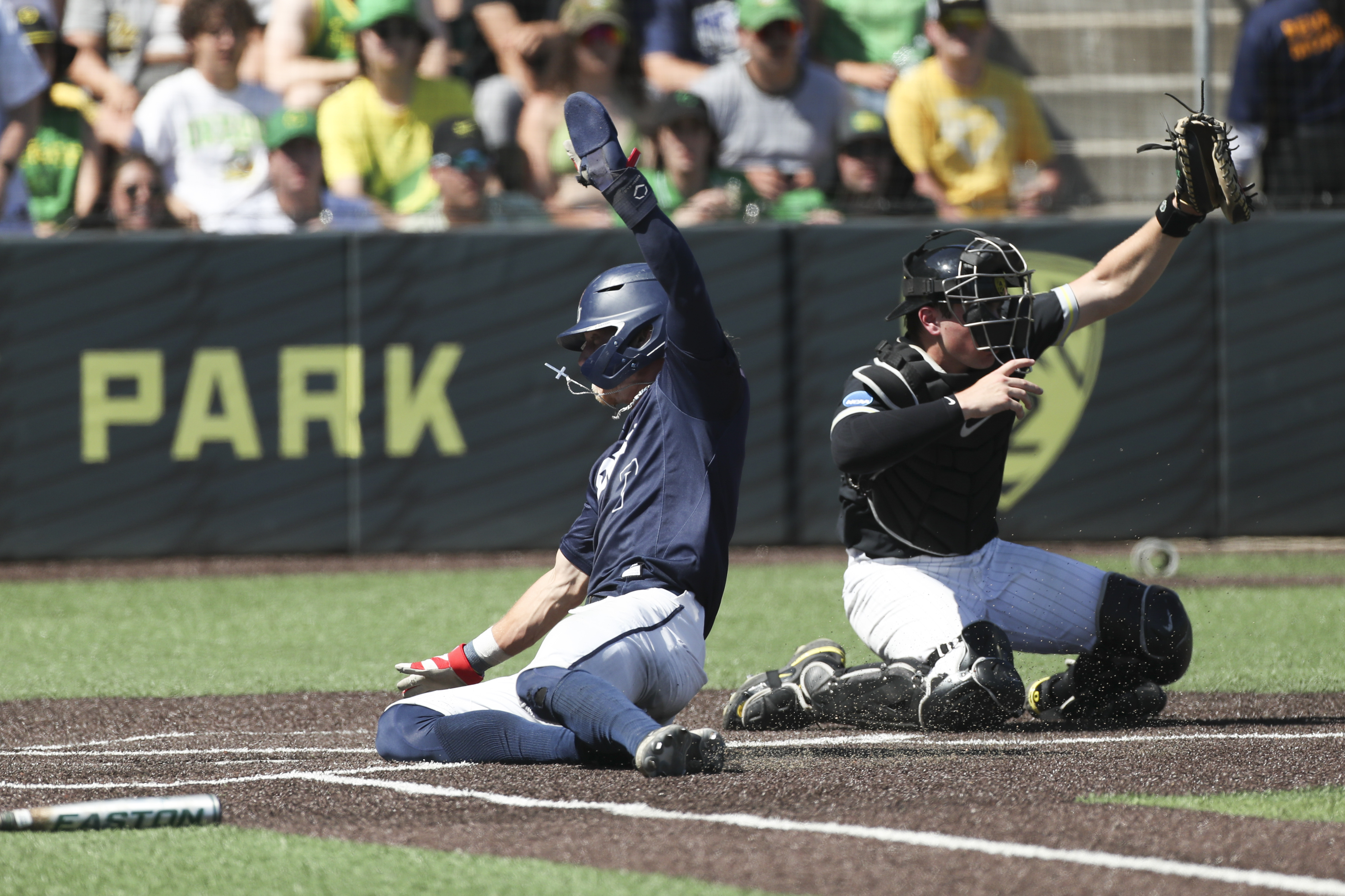 Oral Roberts utility Jonah Cox, left, slides home to score past Oregon catcher Bennett Thompson, right, during the third inning of an NCAA college baseball tournament super regional game Sunday, June 11, 2023, in Eugene, Ore.