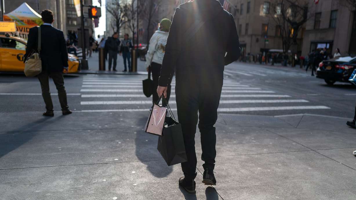 People walk along 5th Avenue in Manhattan, one of the nation's premier shopping streets, on Feb. 15 in New York City. Baby Boomers are living it up, splurging on cruises and restaurants. Younger Americans are struggling just to keep up.