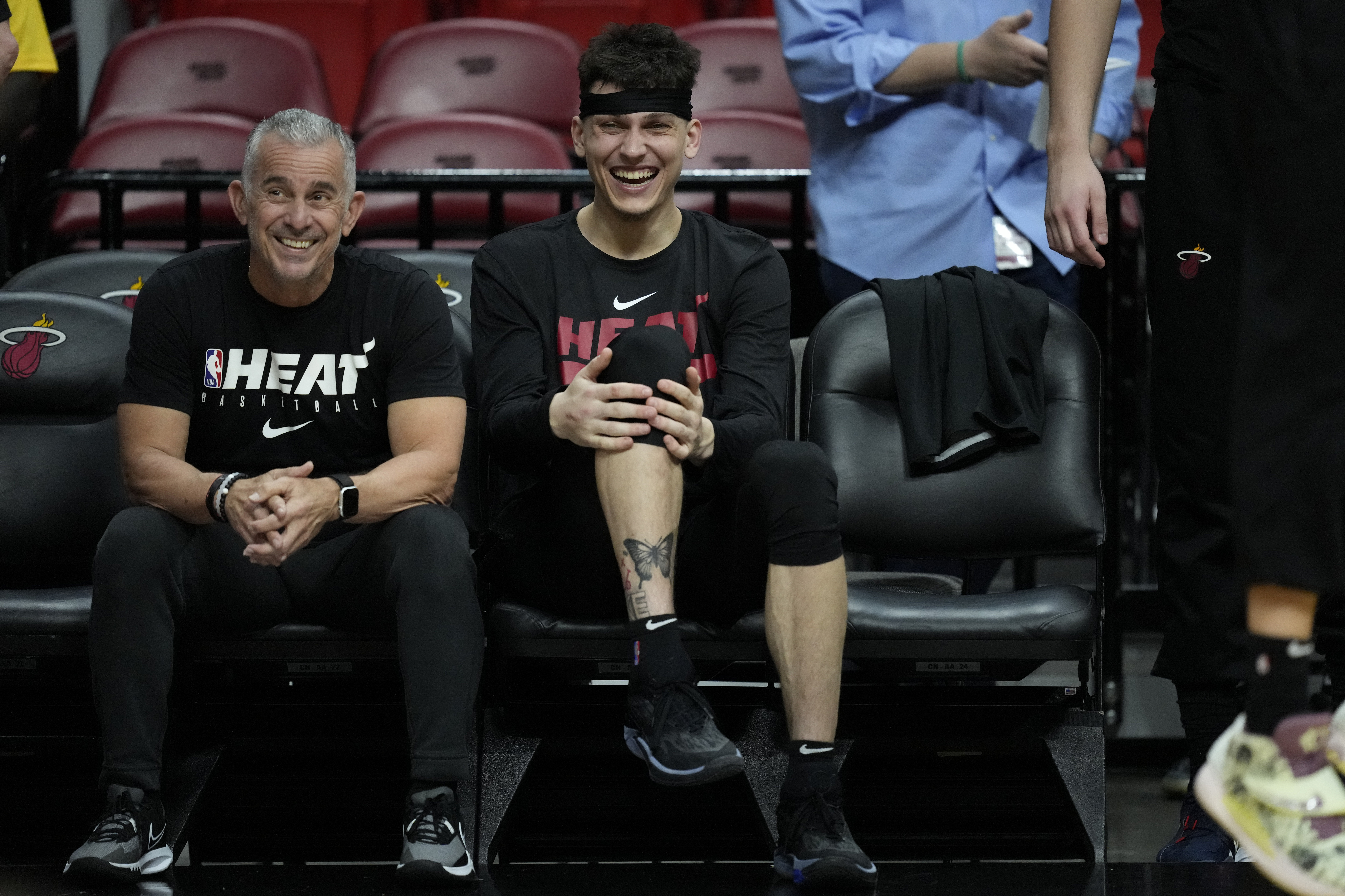 Miami Heat guard Tyler Herro, right, laughs as he watches from the bench during a practice ahead of Game 3 of the NBA Finals, at the Kaseya Center in Miami, Tuesday, June 6, 2023.