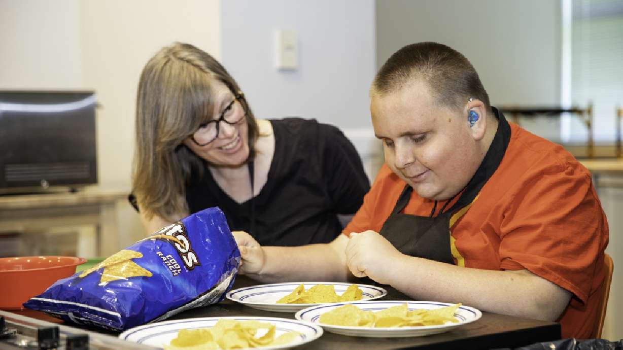 Randy Neumann and his instructor work together to cook nachos during his instruction period on June 8.