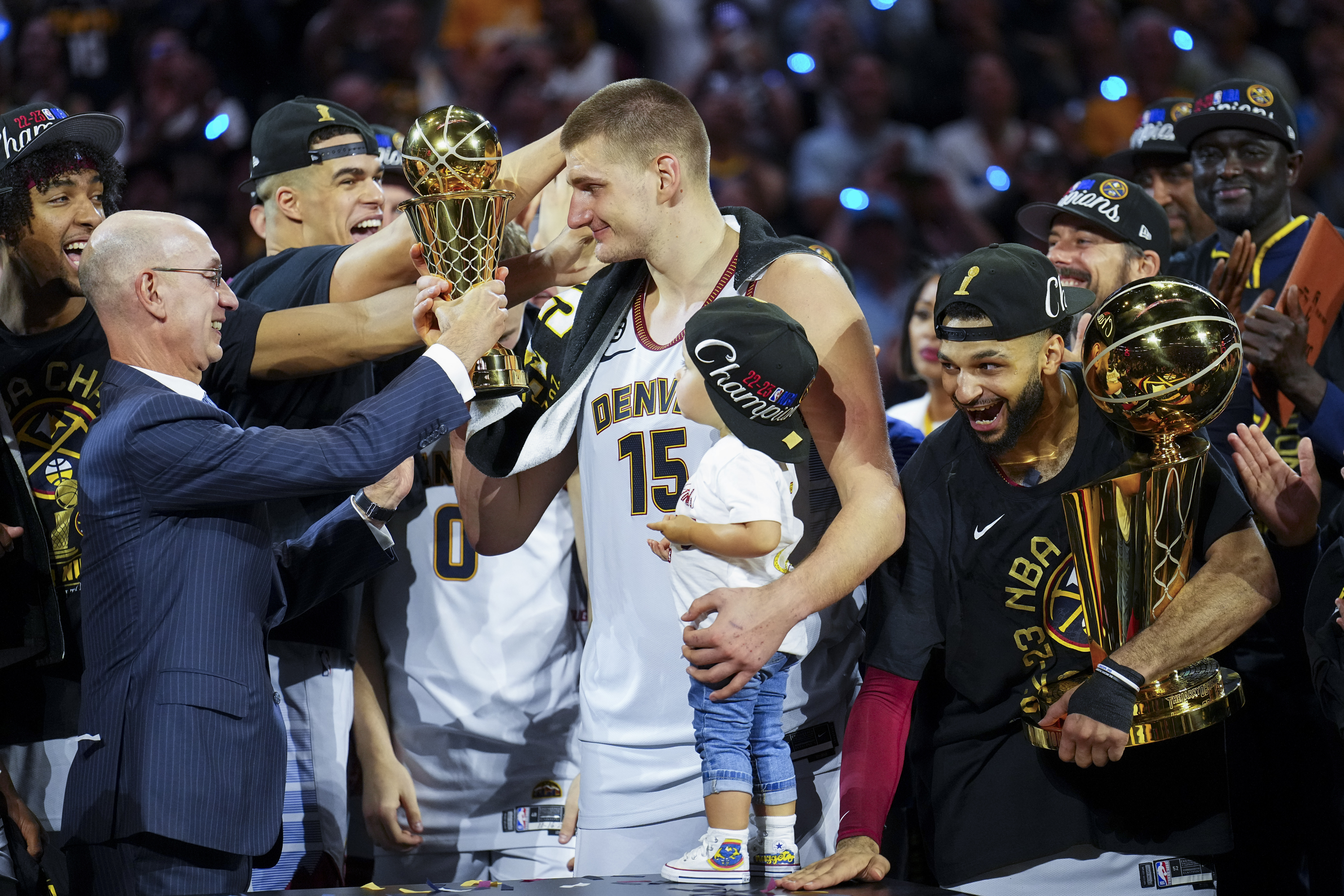 Commissioner Adam Silver, left, hands the MVP award to Denver Nuggets center Nikola Jokic, center, after the team won the NBA Championship with a victory over the Miami Heat in Game 5 of basketball's NBA Finals, Monday, June 12, 2023, in Denver. 