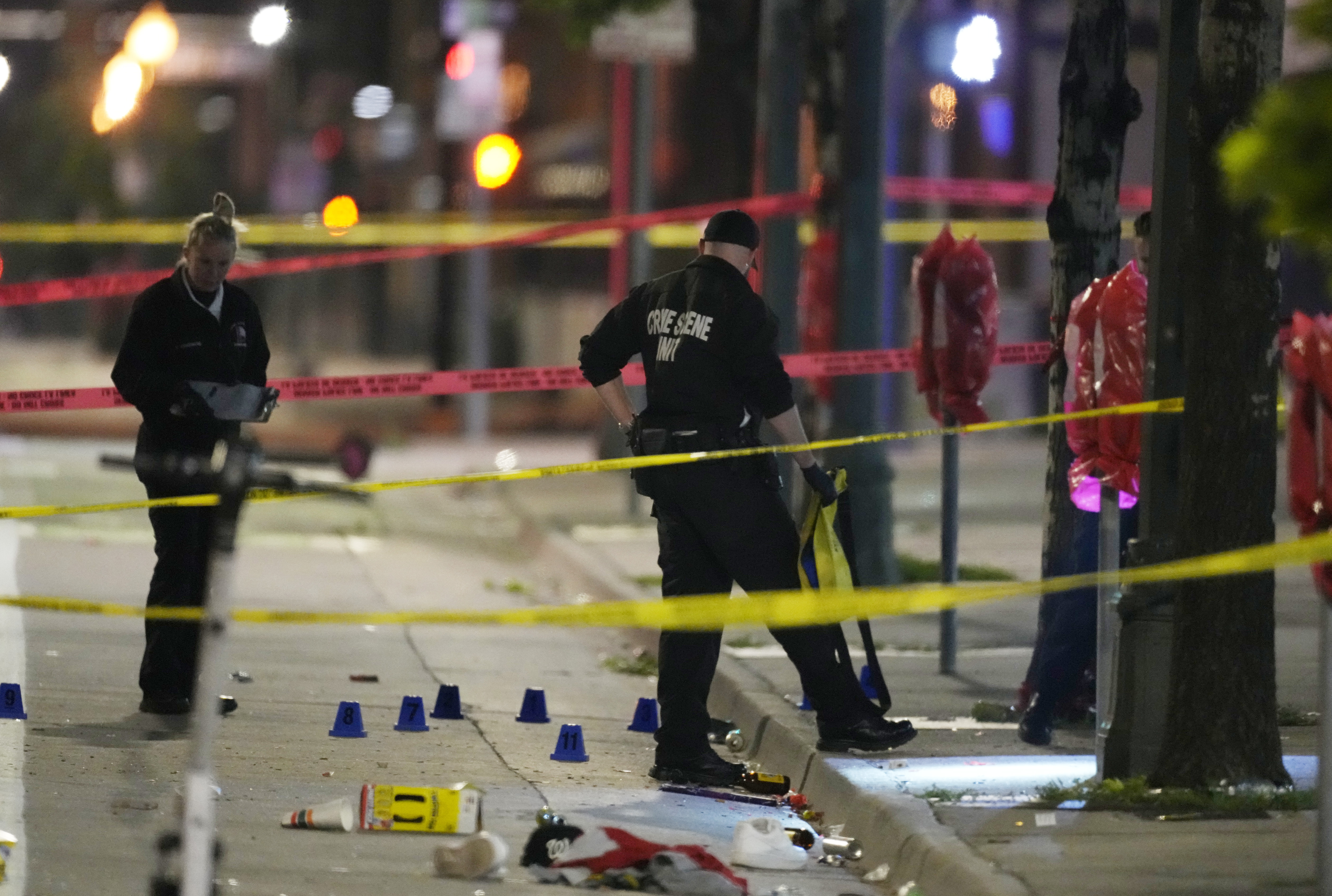 Investigators work the scene of a shooting along Market Street between 20th and 21st avenues during a celebration after the Denver Nuggets won the team's first NBA Championship early Tuesday in Denver. 