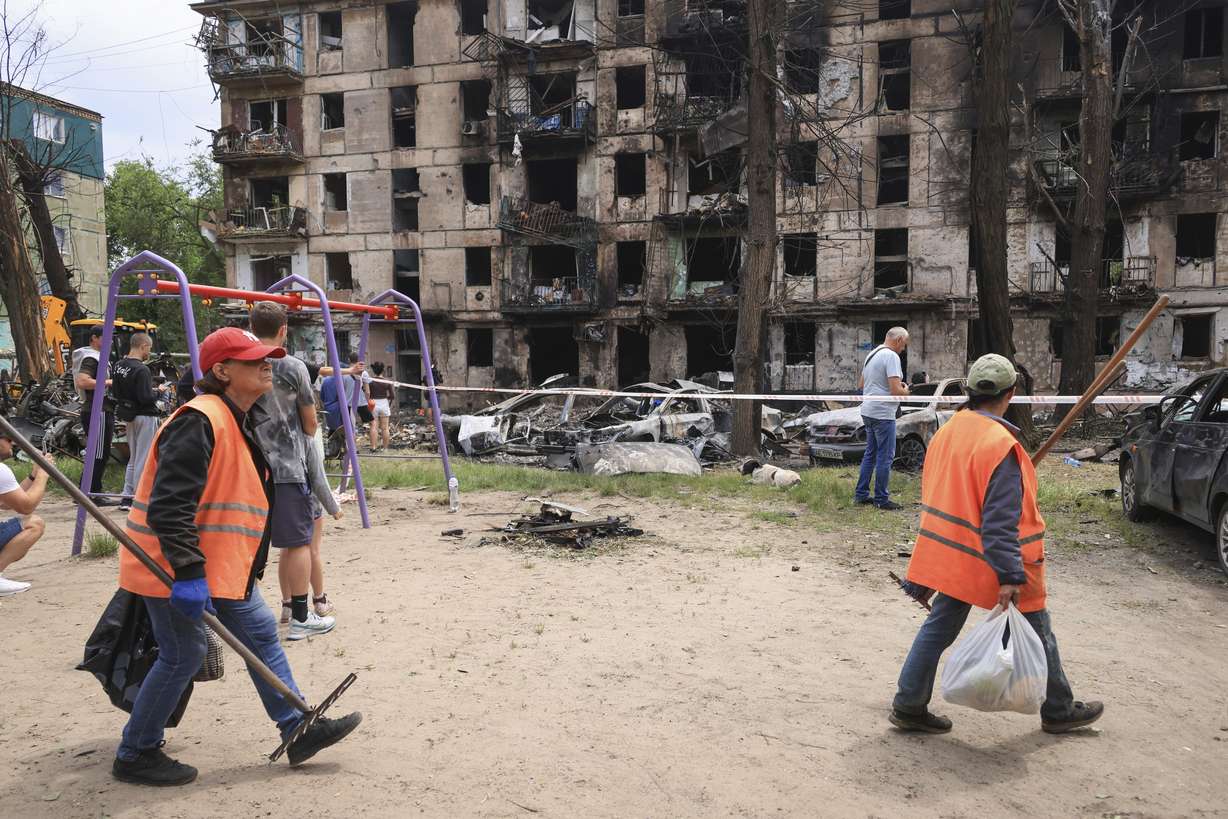 Municipal workers clean the site of the latest Russian rocket attack that damaged a multi-storey apartment building in Kryvyi Rih, Ukraine, Tuesday.