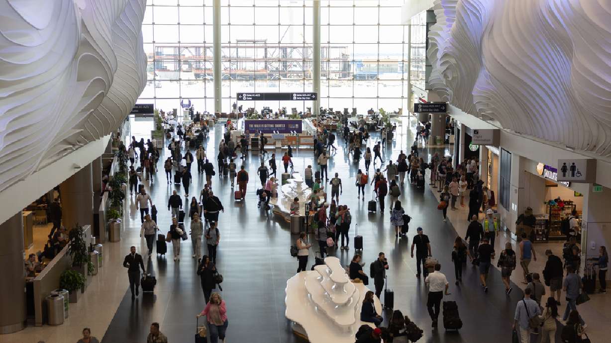 Travelers mingle at the Salt Lake City International Airport in Salt Lake City on May 19. A California man is facing criminal charges after police say he randomly attacked two people at the airport and then tried to disarm two police officers.