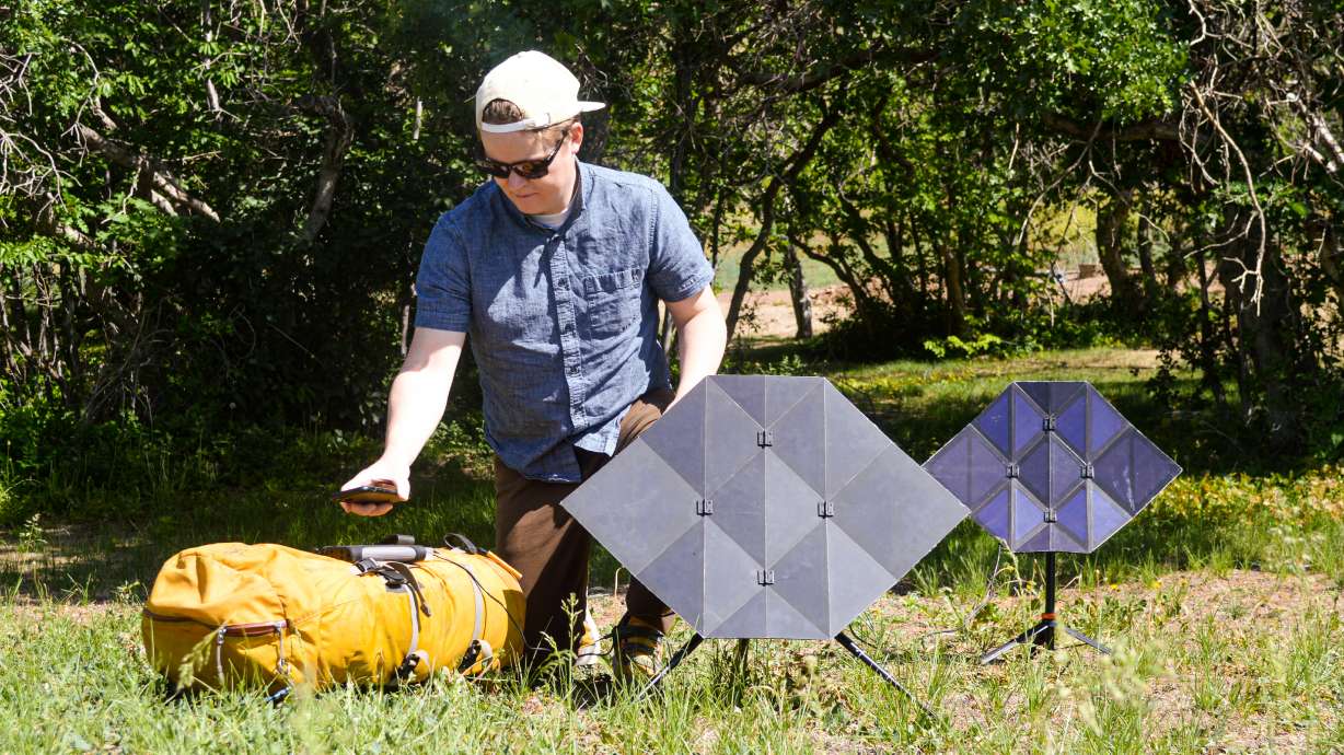 A man unloads his camping gear, charging his electrical devices through the Sego Charger in the meantime.
