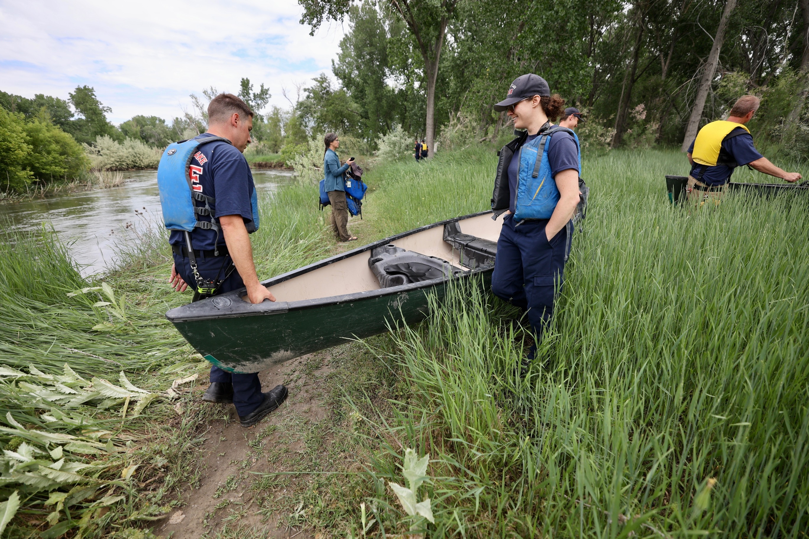 Firefighters retrieve a canoe after several children and two adults fell into the Jordan River when a pair of canoes capsized on Tuesday.