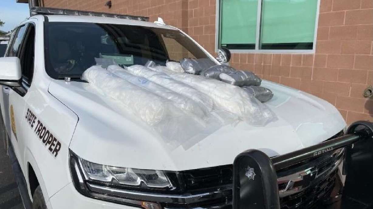 Utah Highway Patrol vehicle with bags of narcotics on its hood. Sixty pounds of methamphetamine and three kilos of fentanyl pills were seized during a traffic stop in Cedar City on Saturday.