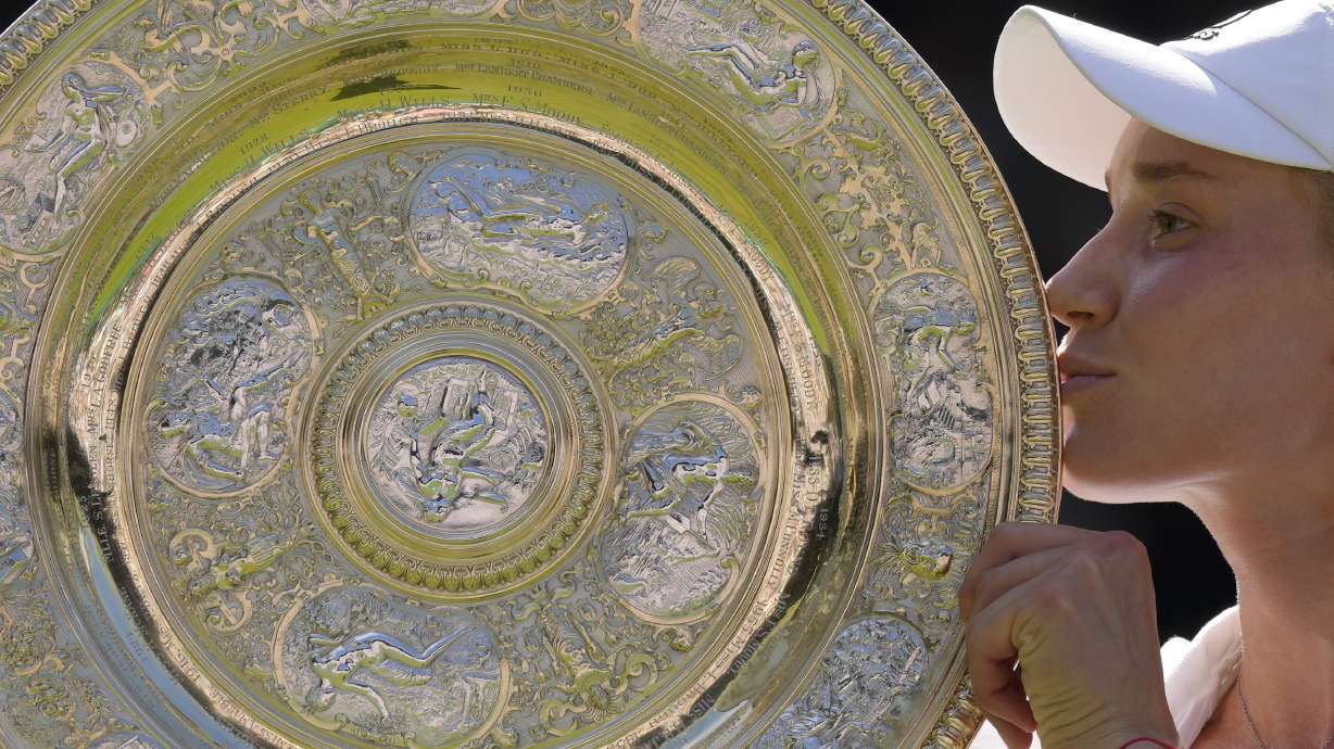 FILE - Kazakhstan's Elena Rybakina kisses the trophy as she celebrates after beating Tunisia's Ons Jabeur to win the final of the women's singles on day thirteen of the Wimbledon tennis championships in London, Saturday, July 9, 2022. Prize money at Wimbledon this year will rise by more than 11% to 44.7 million pounds ($56.5 million). It is an increase of 17.1% on the last Wimbledon before the pandemic in 2019. The winners of the singles will each receive 2.35 million pounds ($3 million). Those earnings are back to the levels they were in 2019.