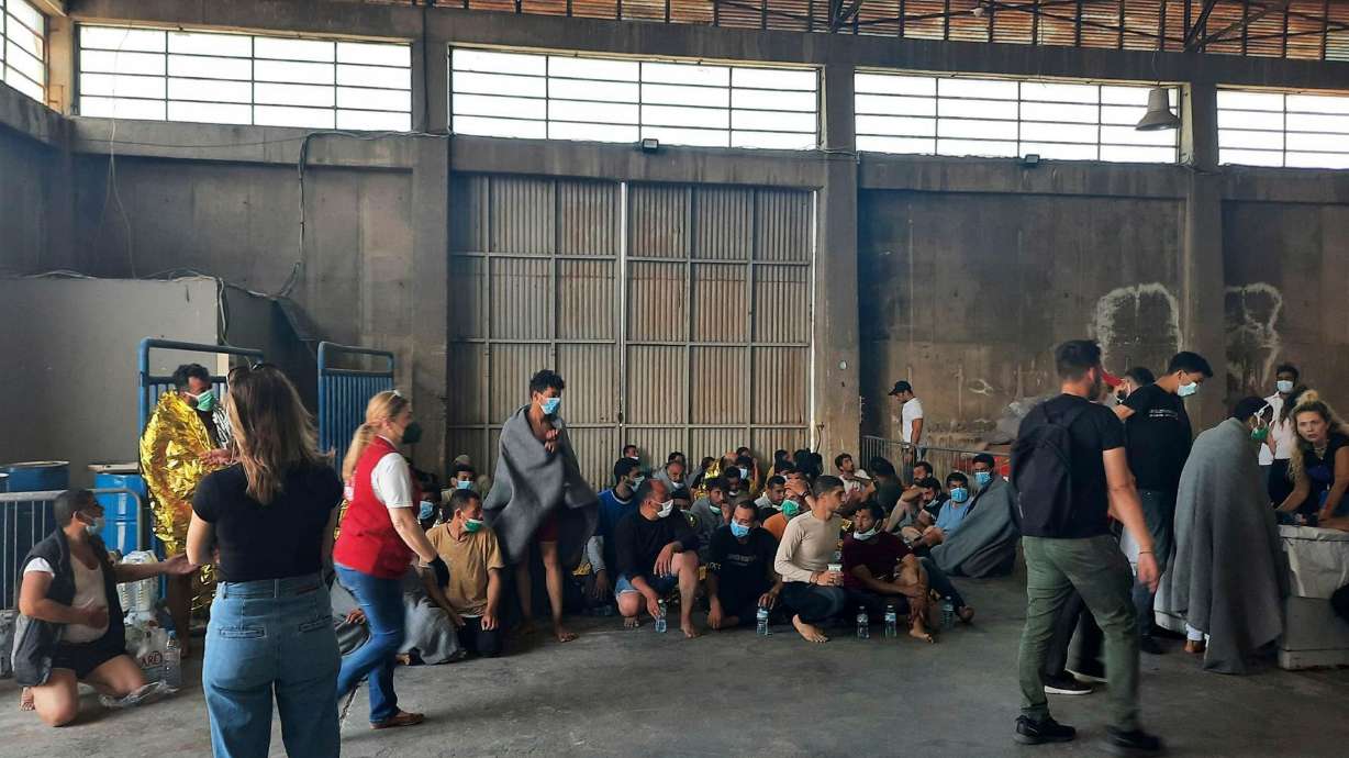 Survivors sit in a warehouse at the port in Kalamata town on Wednesday. At least 79 people died after a migrant boat carrying hundreds of people sank off the Greek coast.