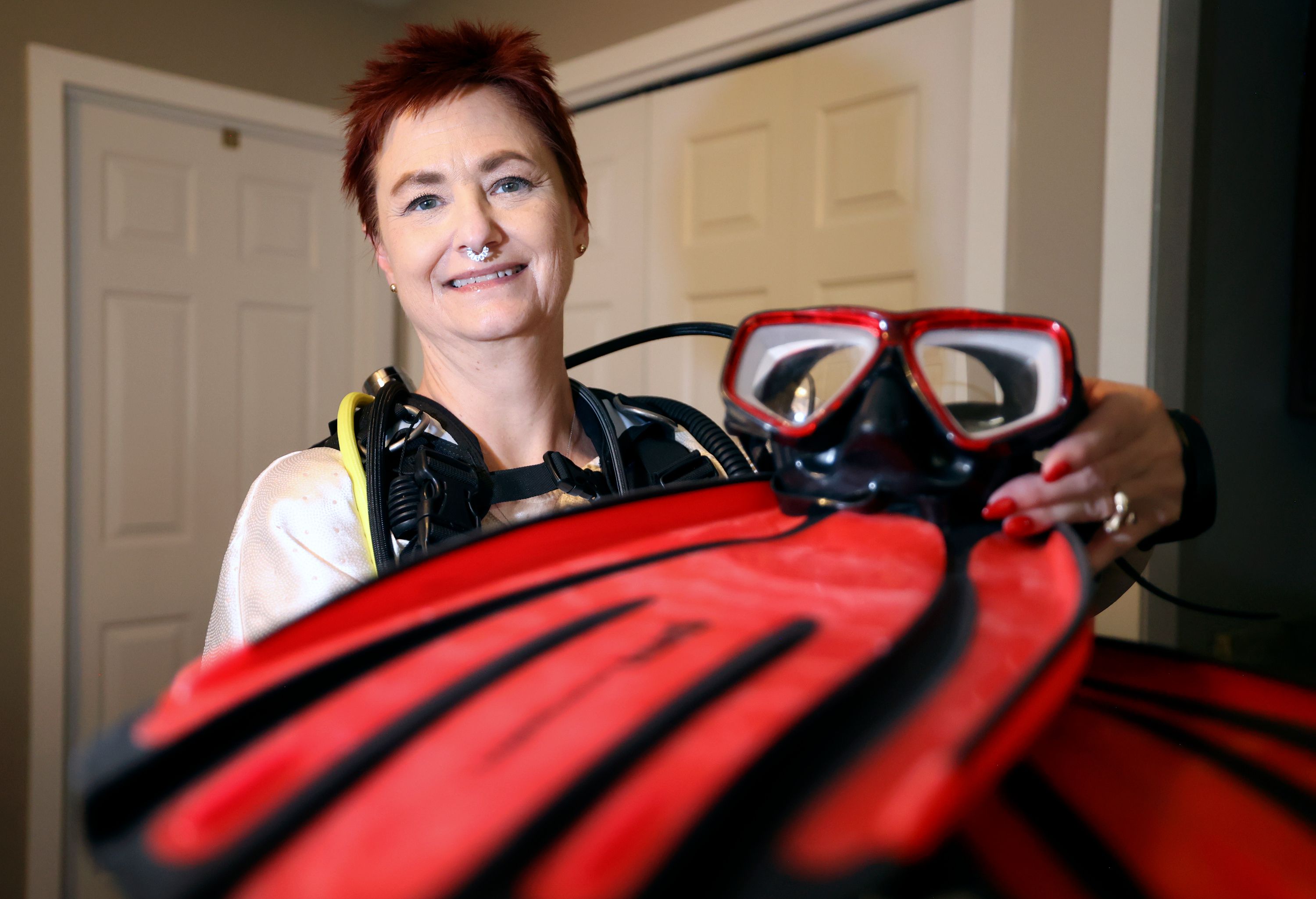 Amanda Jenson shows her scuba diving gear at her home in Murray on Monday. Jenson is planning a scuba diving trip to Mexico.