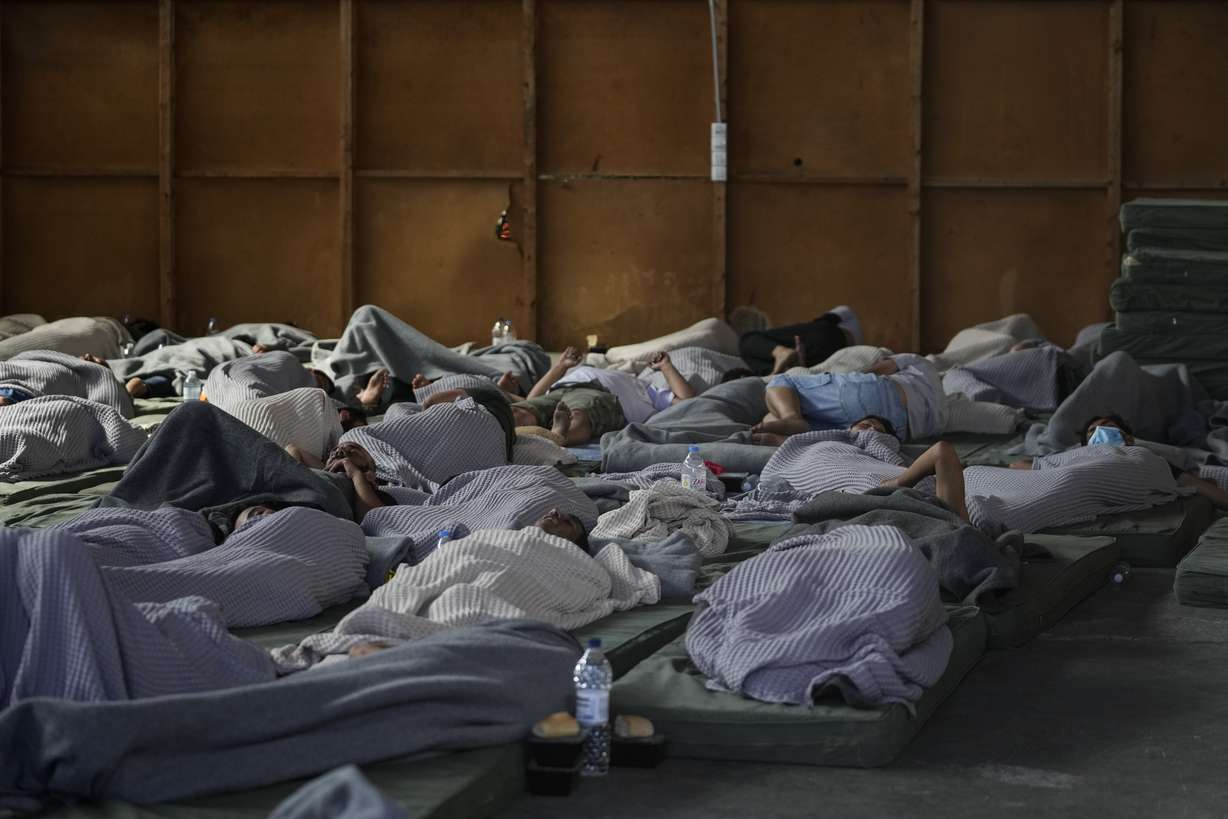 Survivors of a shipwreck sleep at a warehouse at the port in Kalamata town, about 150 miles southwest of Athens, Wednesday. A fishing boat carrying migrants capsized and sank off the coast of Greece on Wednesday, authorities said, leaving at least 78 people dead and many dozens feared missing in one of the worst disasters of its kind this year.
