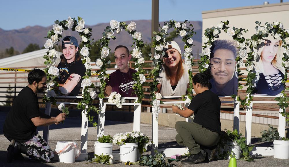 Noah Reich, left, and David Maldonado, the Los Angeles co-founders of Classroom of Compassion, set up a memorial near Club Q in Colorado Springs, Colo., on Nov. 22, 2022, with photographs of the five victims of a mass shooting at the gay nightclub.