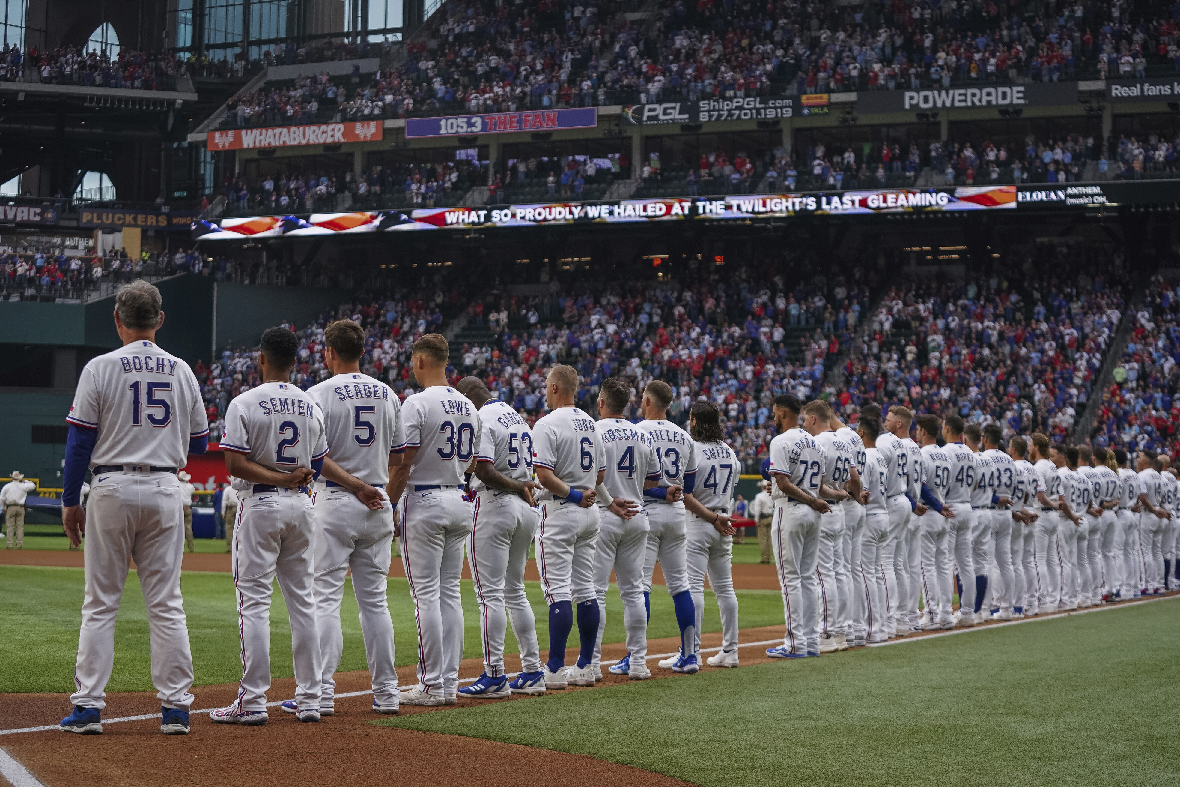 FILE - The Texas Rangers stand for the playing of the national anthem before an opening day baseball game against the Philadelphia Phillies on March 30, 2023, in Arlington, Texas. An annual study reviewing diversity hiring for Major League Baseball on Thursday, June 15, reported a record low of Black players on opening-day rosters for the second straight year.