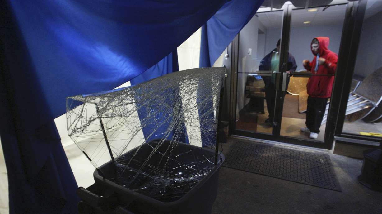 FILE - Nick Sopchak, right, looks at broken glass from a rear door of the Everhart Museum, Friday, Nov. 18, 2005, in Scranton, Pa. Federal authorities announced charges against a ring of nine people for thefts of millions of dollars worth of paintings, sports memorabilia and other valuables. The thefts took place over more than two decades at 20 different museums and institutions across Pennsylvania, New Jersey, New York and North Dakota, the U.S. Attorney for the Middle District of Pennsylvania said Thursday, June 15, 2023.