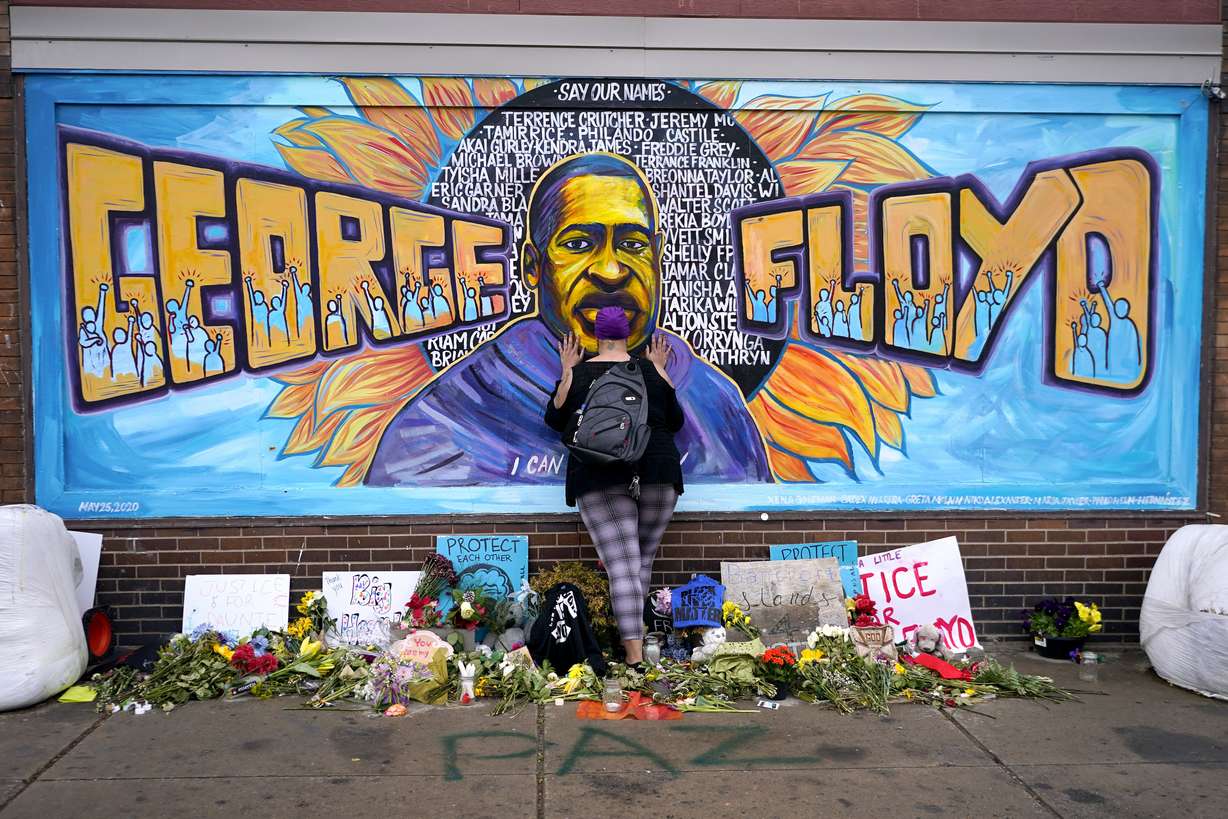 Damarra Atkins pays respect to George Floyd at a mural at George Floyd Square in Minneapolis, April 23, 2021.