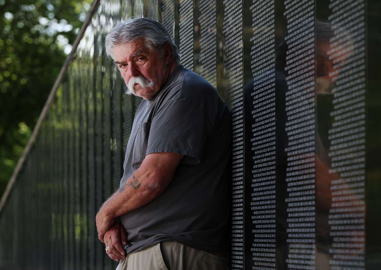 Military veteran Terry McDade, an engineering technician in the Ogden Air Logistics Complex's 309th Aircraft Maintenance Group, recently received national recognition for his achievements in disability employment. McDade poses for photos at Layton's Vietnam Memorial Wall replica on Tuesday.