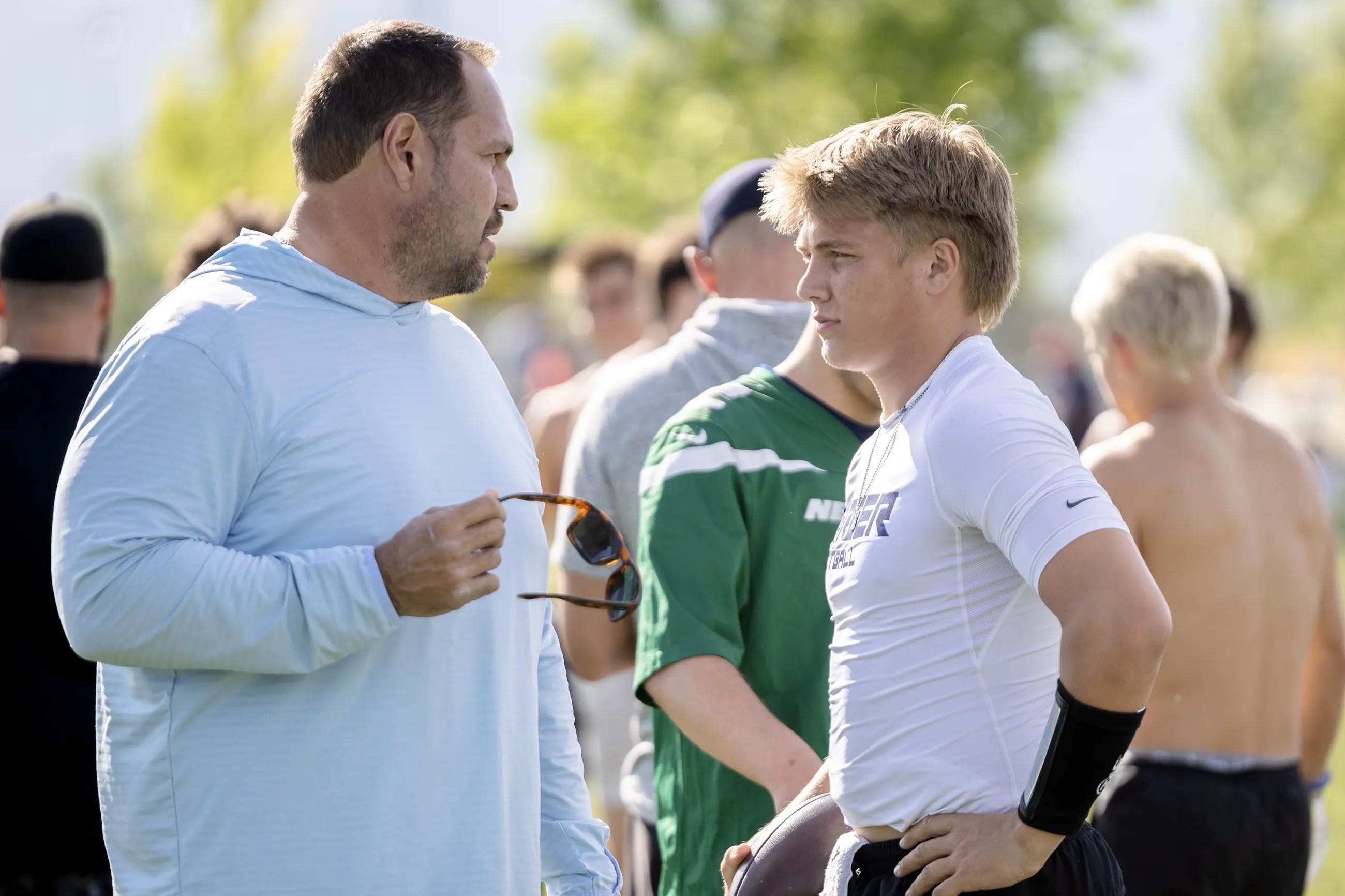 Mike Wilson talks with his son Isaac Wilson during a seven-on-seven passing league game in Layton on Friday, June 9.