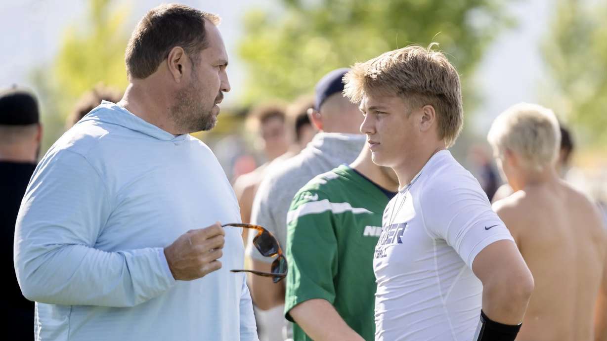 Mike Wilson talks with his son Isaac Wilson during a seven-on-seven passing league game in Layton on Friday, June 9.