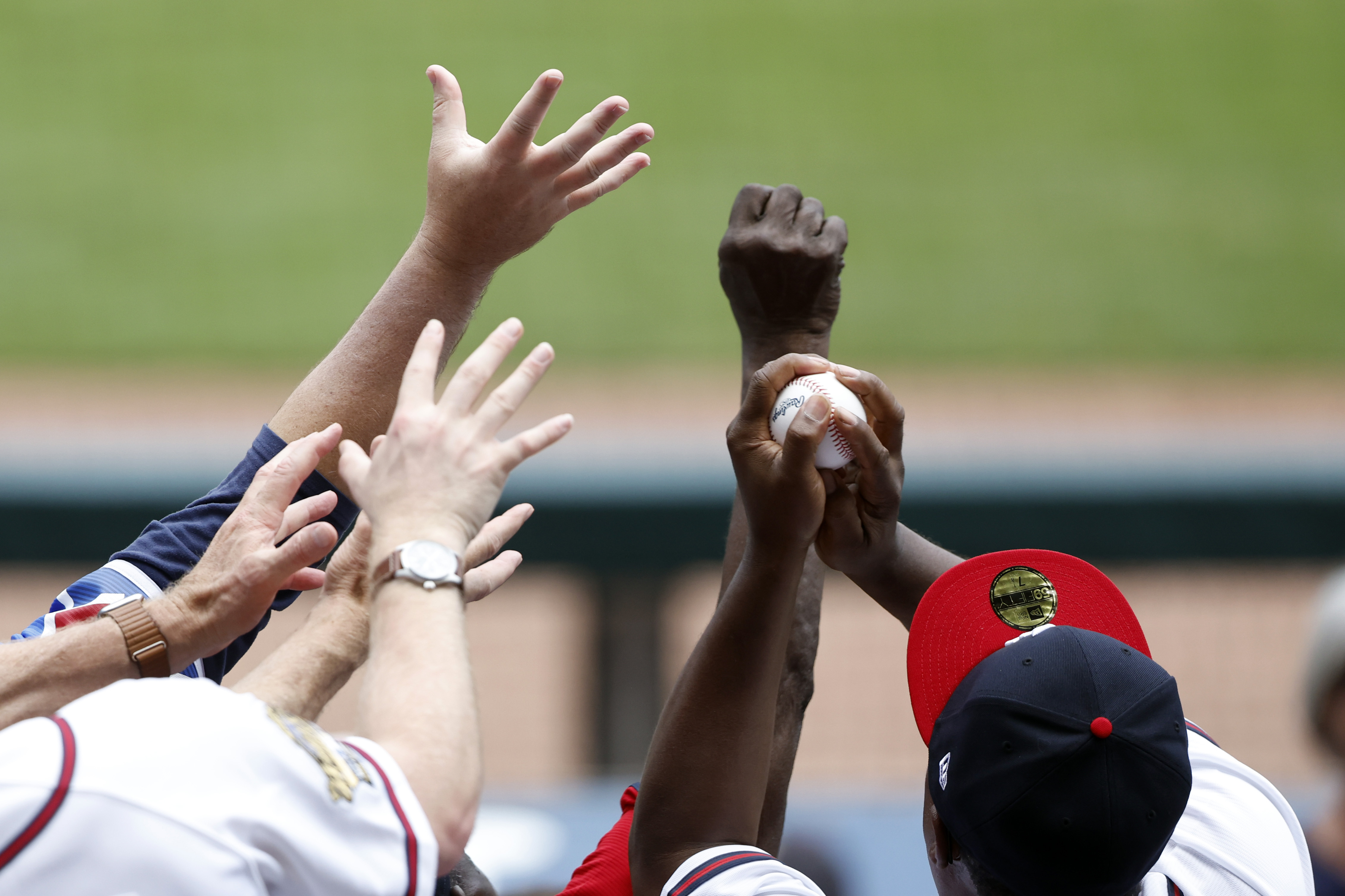 A fan catches a ball thrown into the stands in the sixth inning of a baseball game between the Colorado Rockies and the Atlanta Braves, Sunday, June 18, 2023, in Atlanta. 